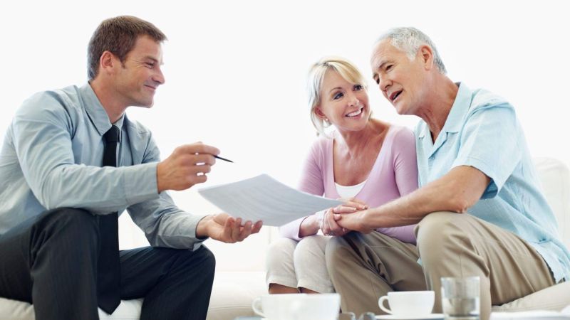 A couple reviews estate planning documents on a couch