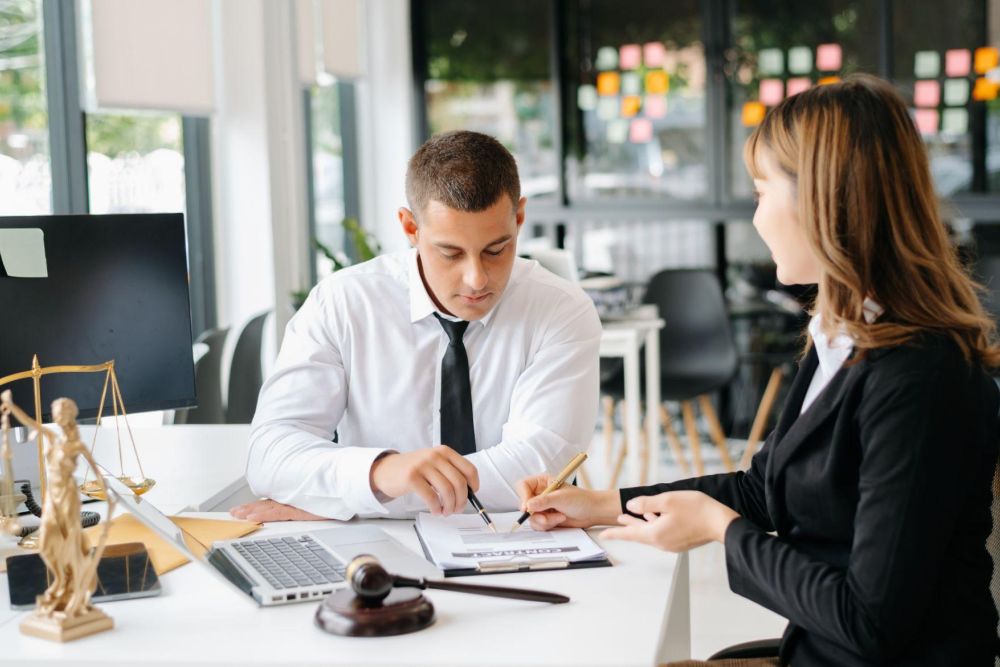 two people reviewing legal documents in an office