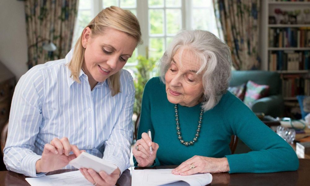 a woman sitting next to an older woman at a table