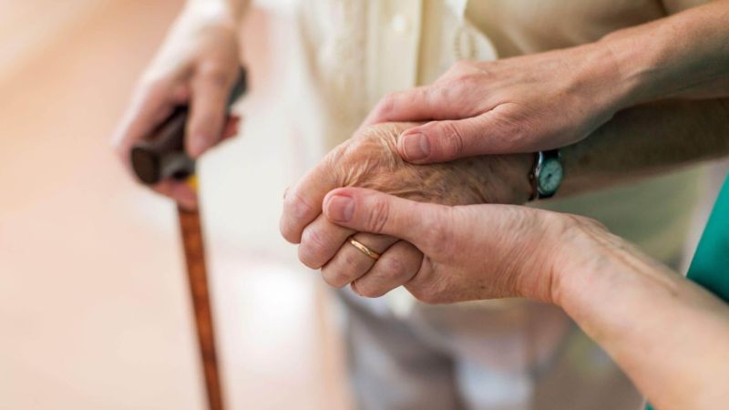 Older woman holding younger woman's
