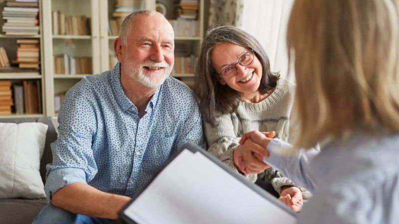 a man and woman sitting on a couch talking to each other