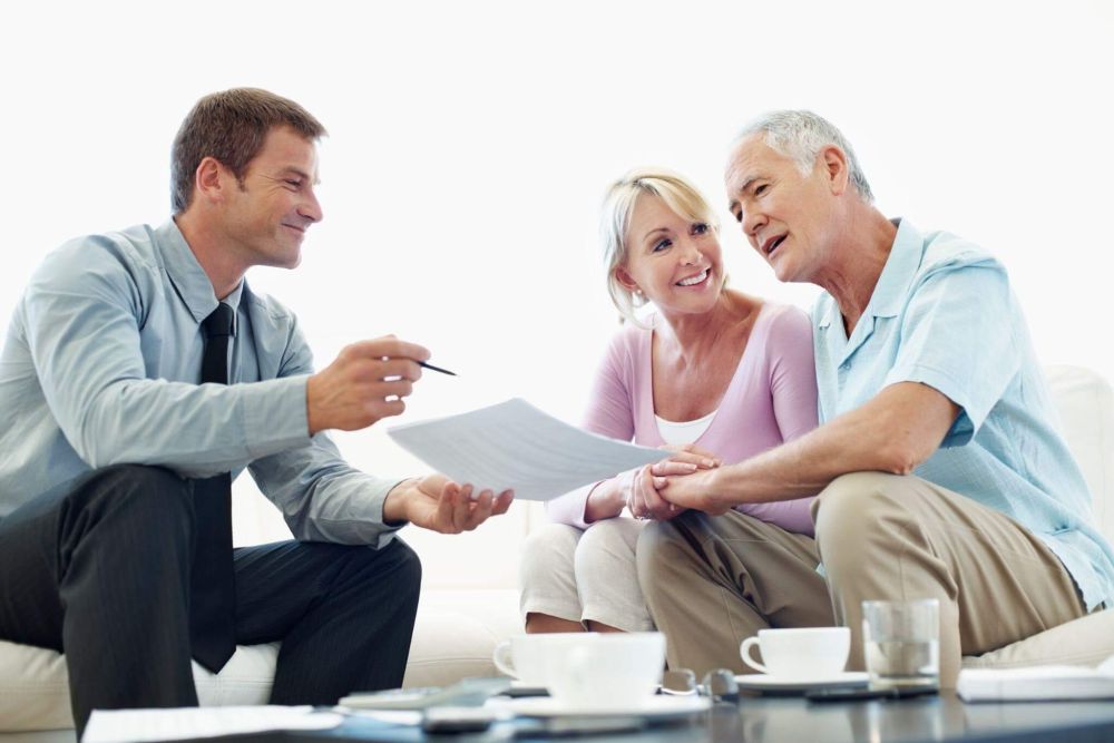 A couple reviews estate planning documents on a couch