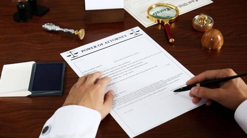 Person writing a Power of Attorney document in