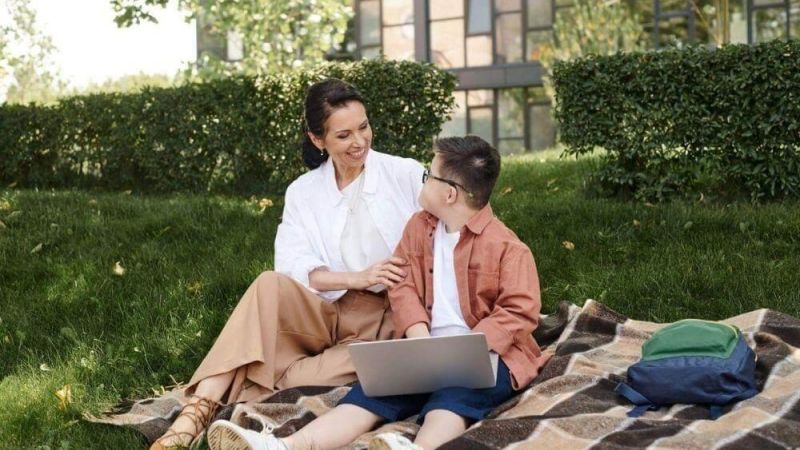 A woman and a boy with a laptop on a