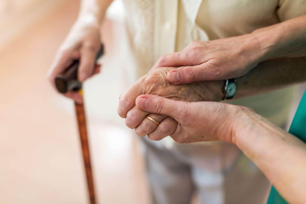 Older woman holding younger woman's