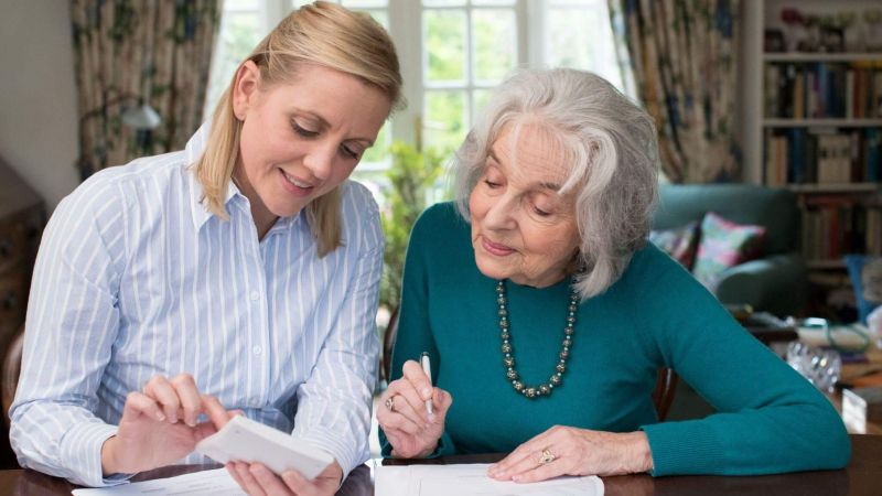 a woman sitting next to an older woman at a table
