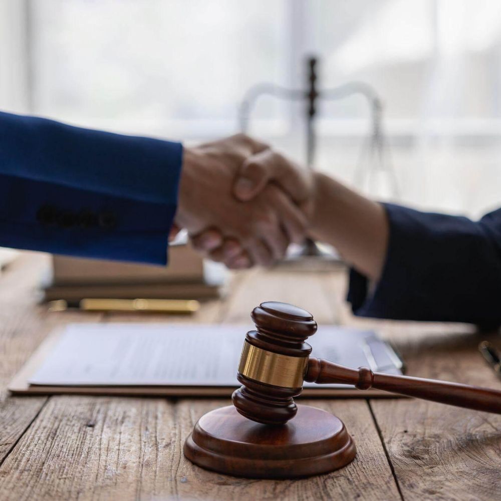 two people shaking hands over a wooden table