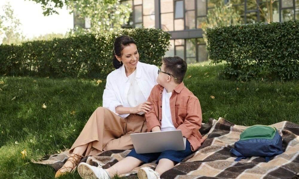 A woman and a boy with a laptop on a