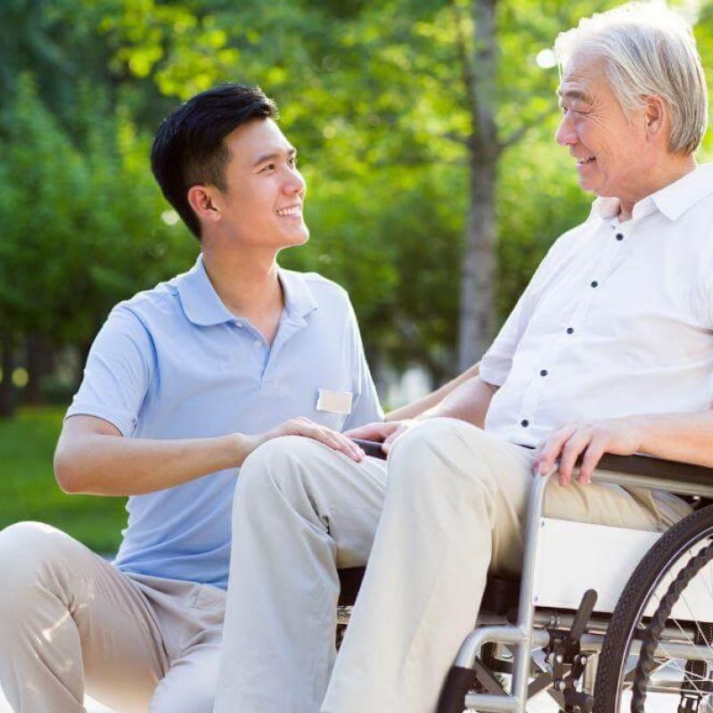 a man in a wheelchair talking to another man