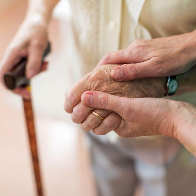 Older woman holding younger woman's