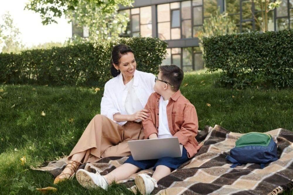 A woman and a boy with a laptop on a