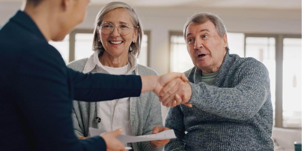 a couple of people shaking hands over a piece of paper