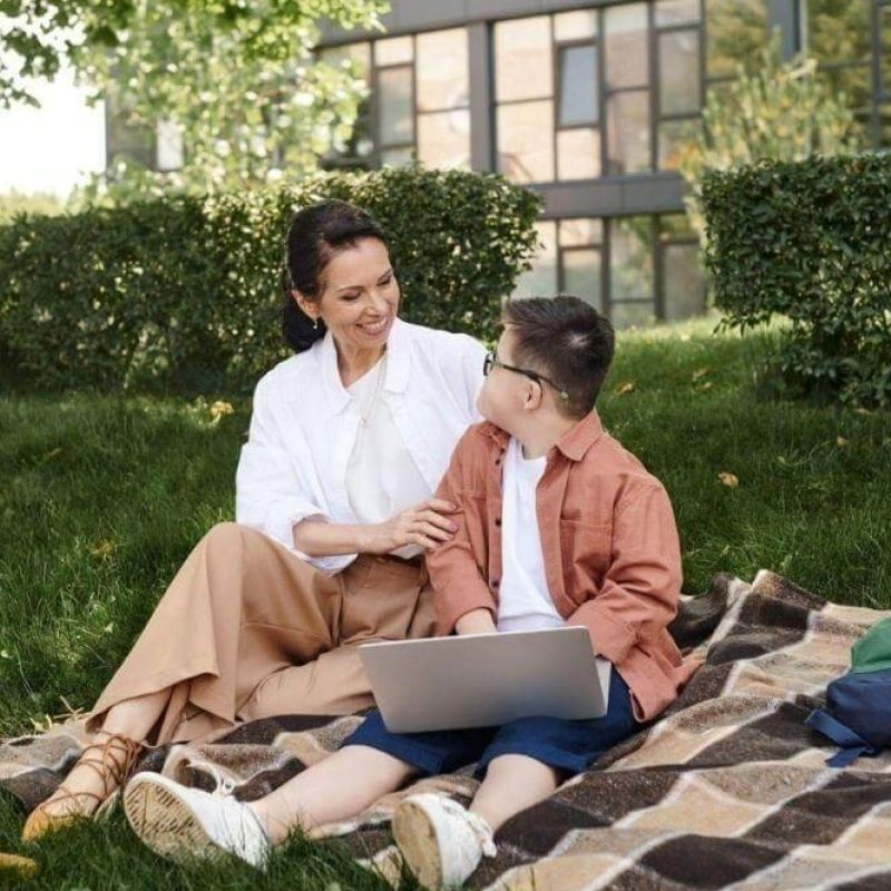 A woman and a boy with a laptop on a