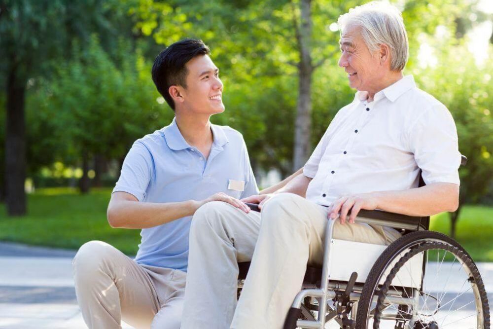 a man in a wheelchair talking to another man