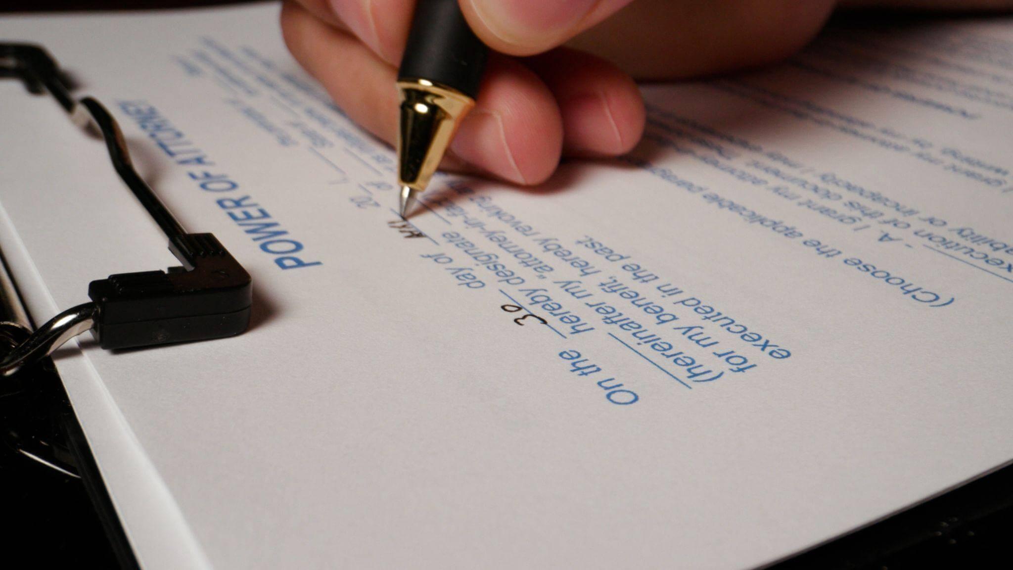 a person writing on a piece of paper with a pen
