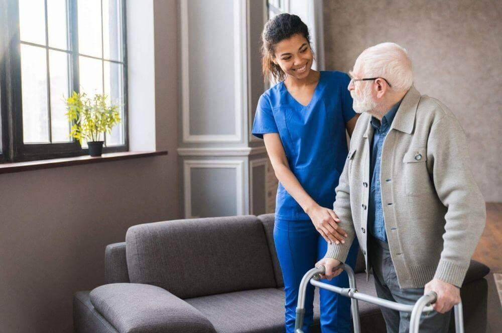 Woman assists elderly man using a walker for mobility support