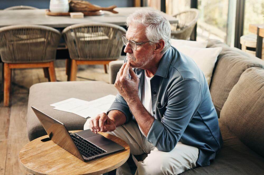 Man on couch using laptop, potentially